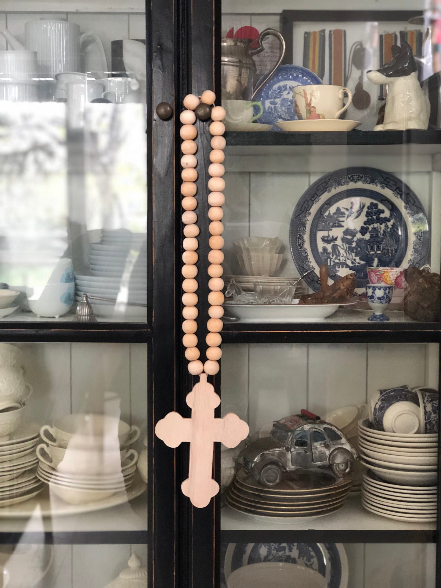 Raven Wall Cross hanging on a display cabinet