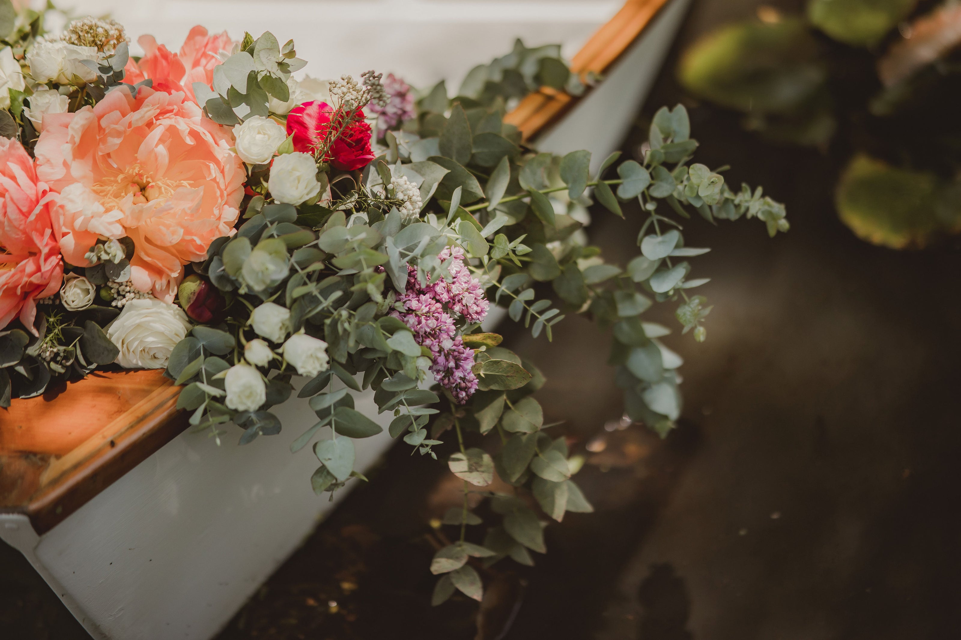 Wedding fresh flower arrangement on the front of a row boat