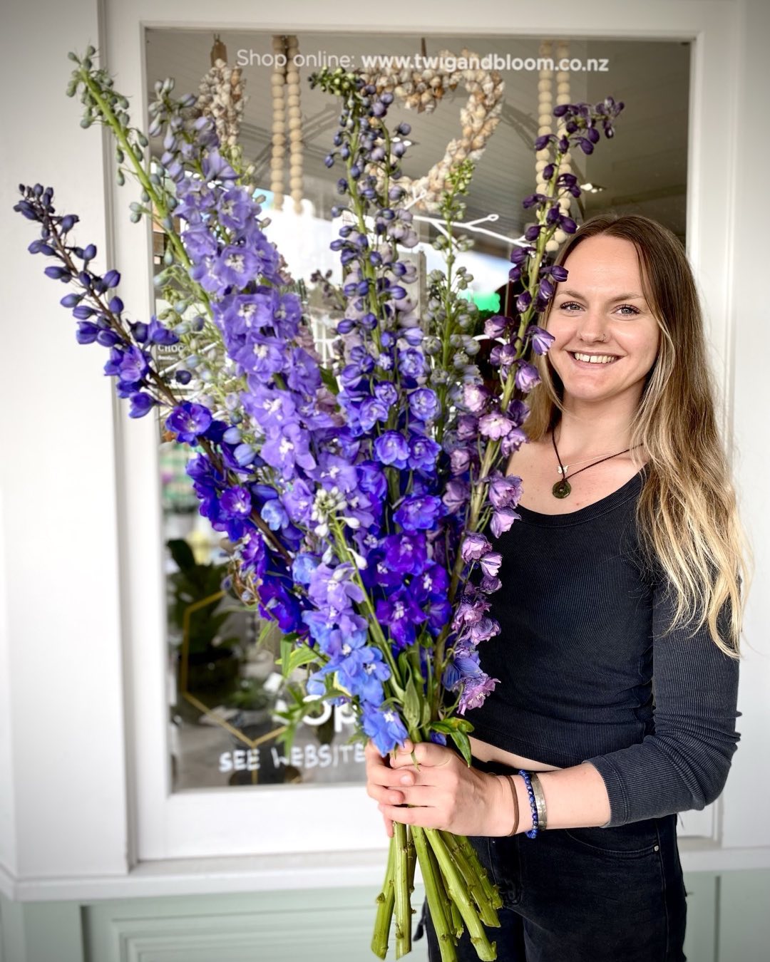 Hannah holding a bunch of fresh delphiniums