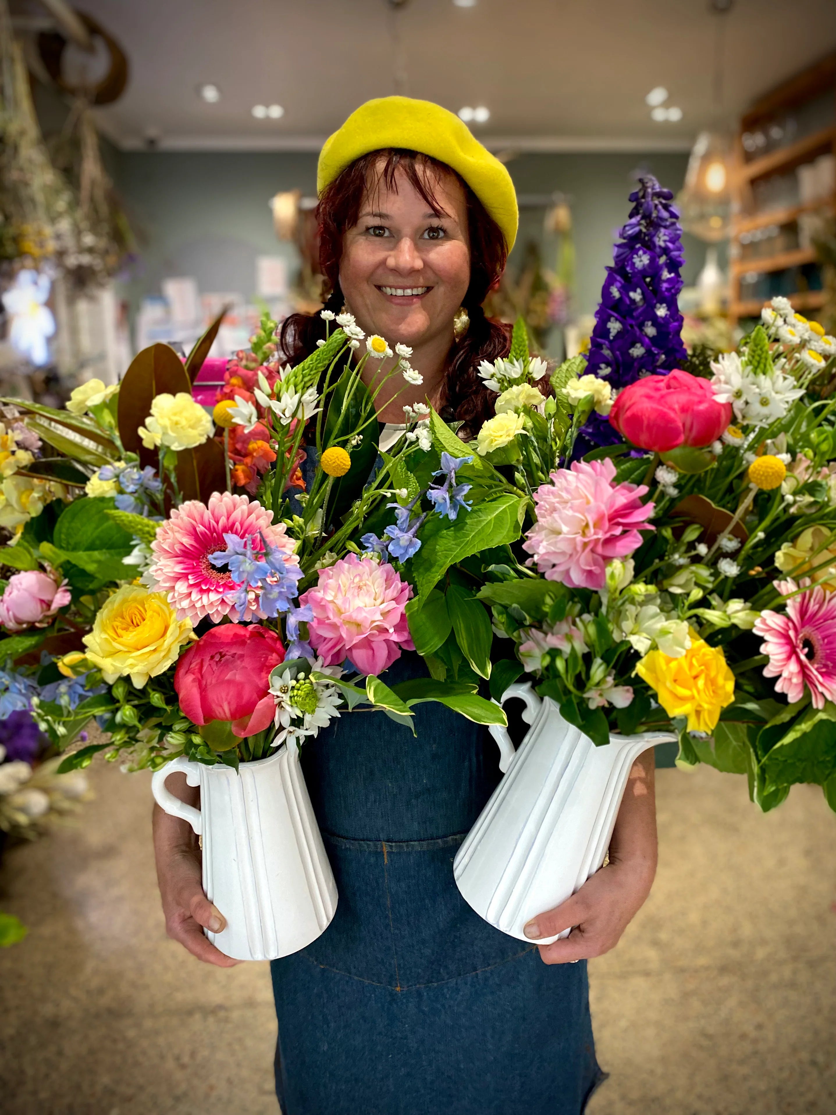 Roi holding two vases of fresh flowers