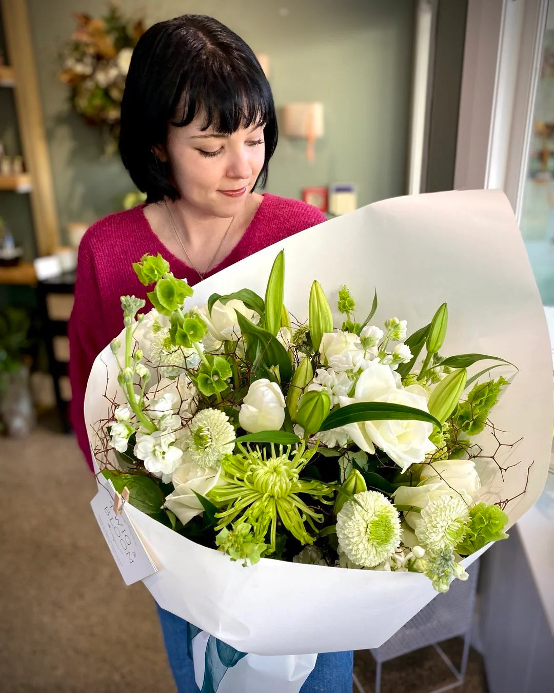 Woman holding an extra large fresh flower bouquet of green and white flowers