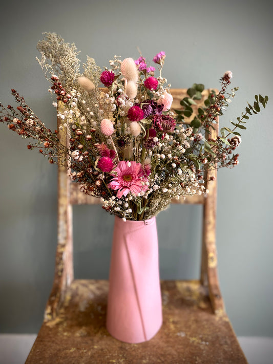 Dried flower arrangement in pink wrap vase
