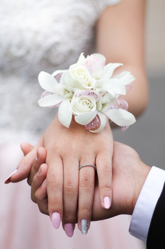 Close up of woman's hand wearing a fresh flower corsage.